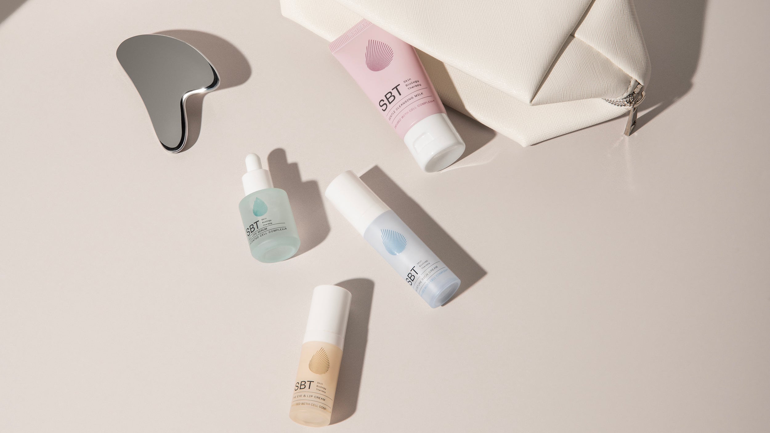 Set of skincare products and a pouch on a light surface