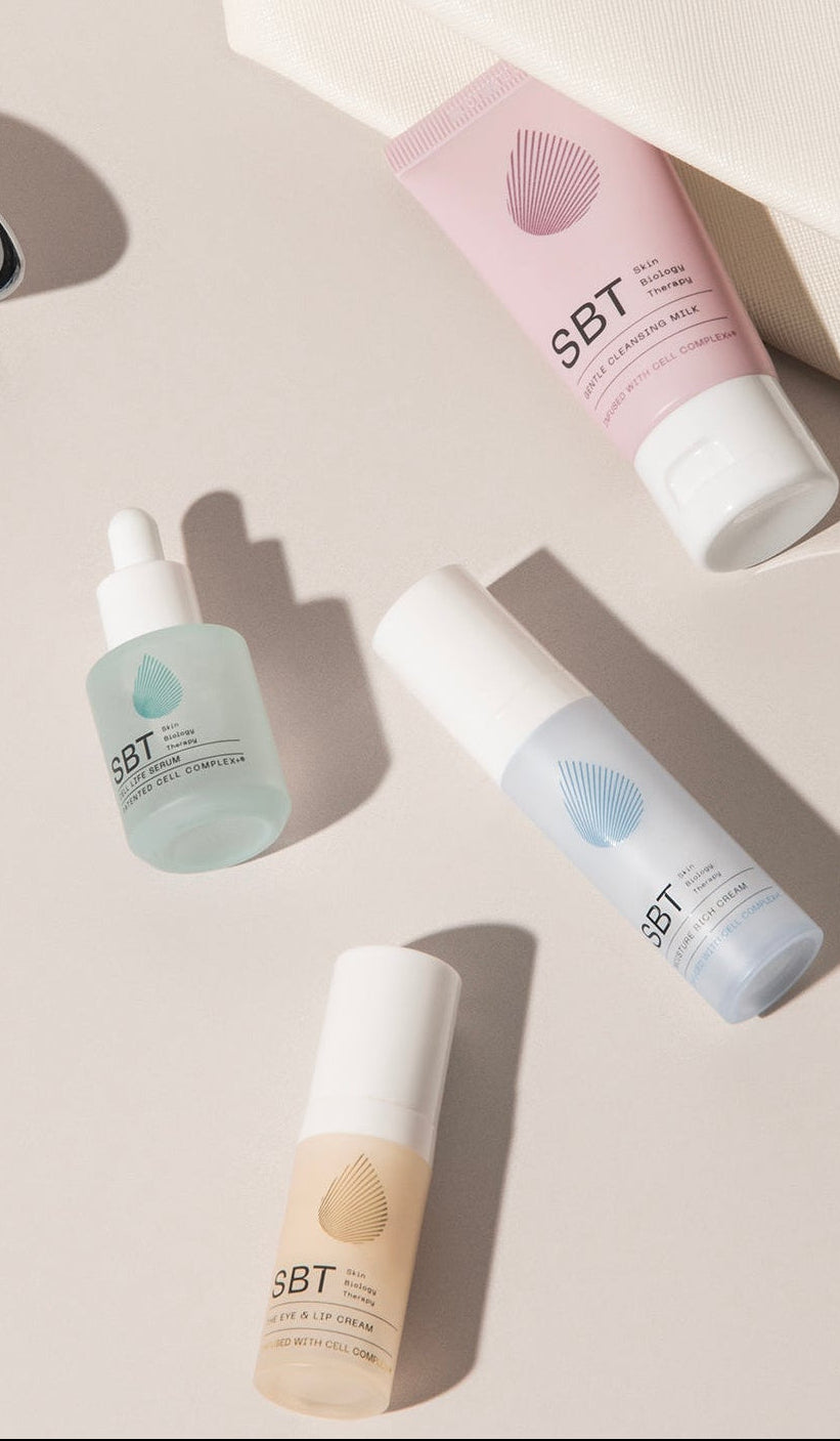 Set of skincare products and a pouch on a light surface