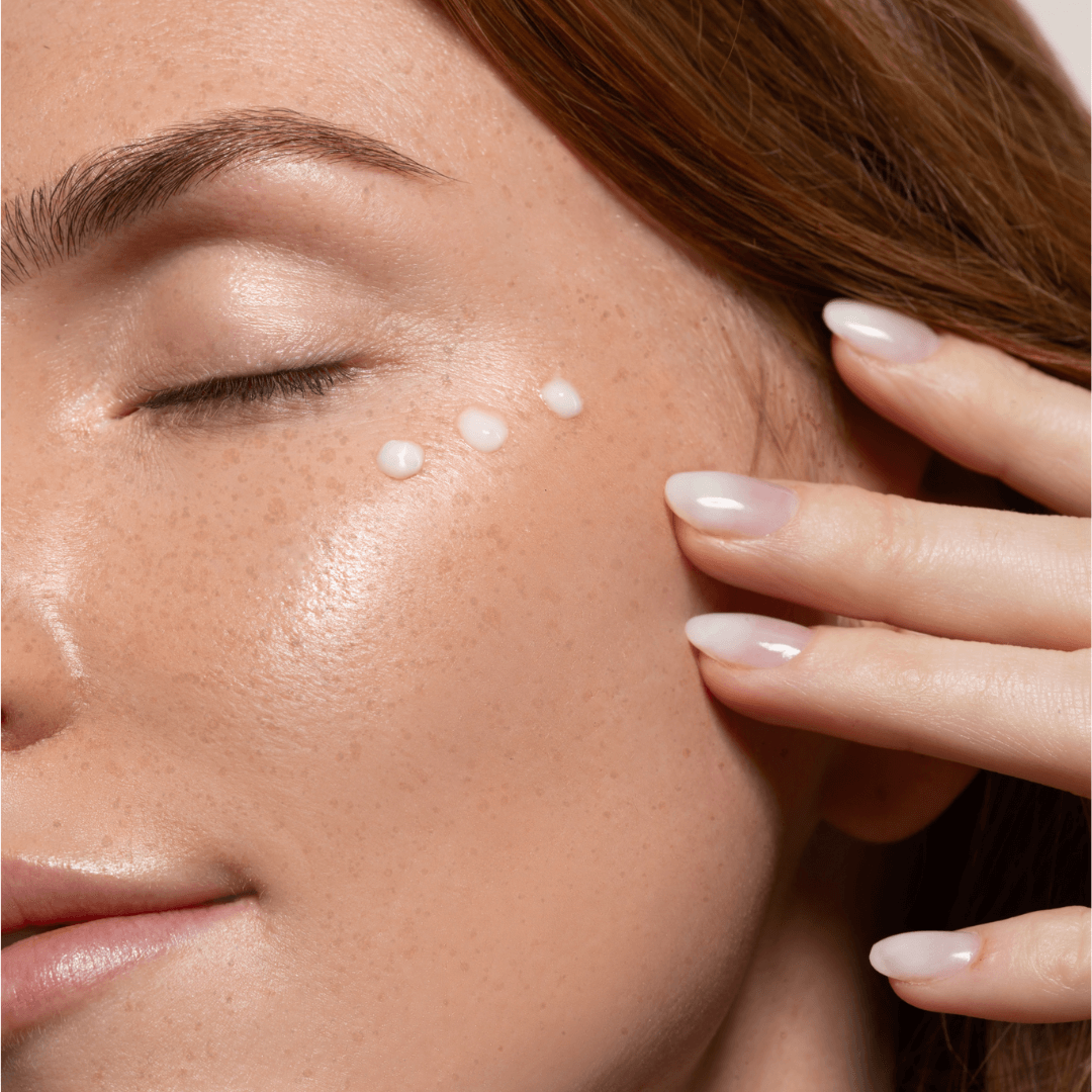 women with skincare liquid on face