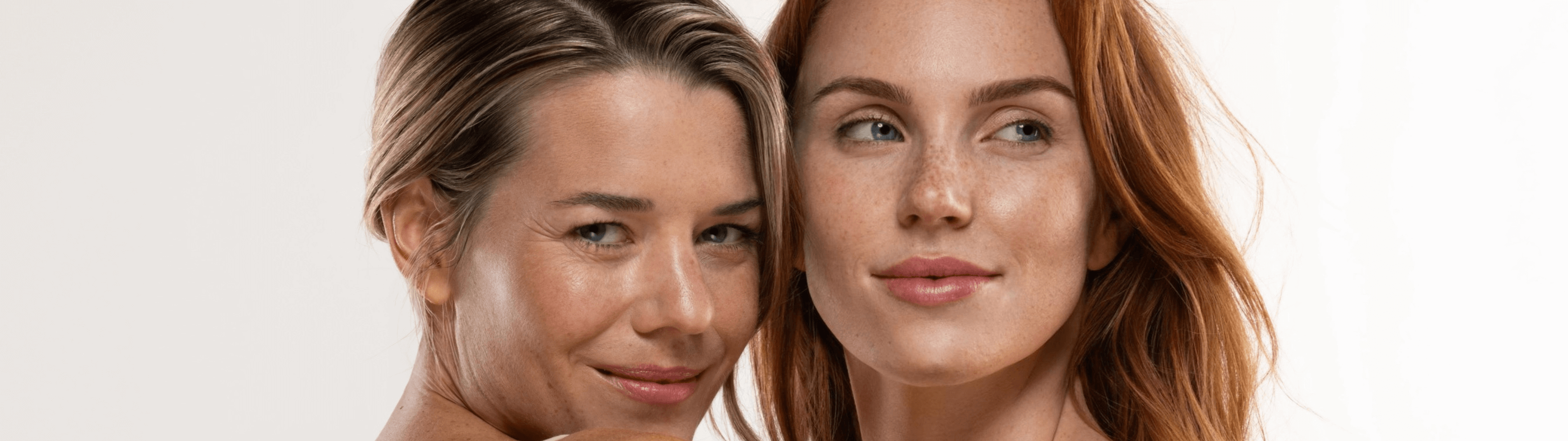 two women posing with beige background