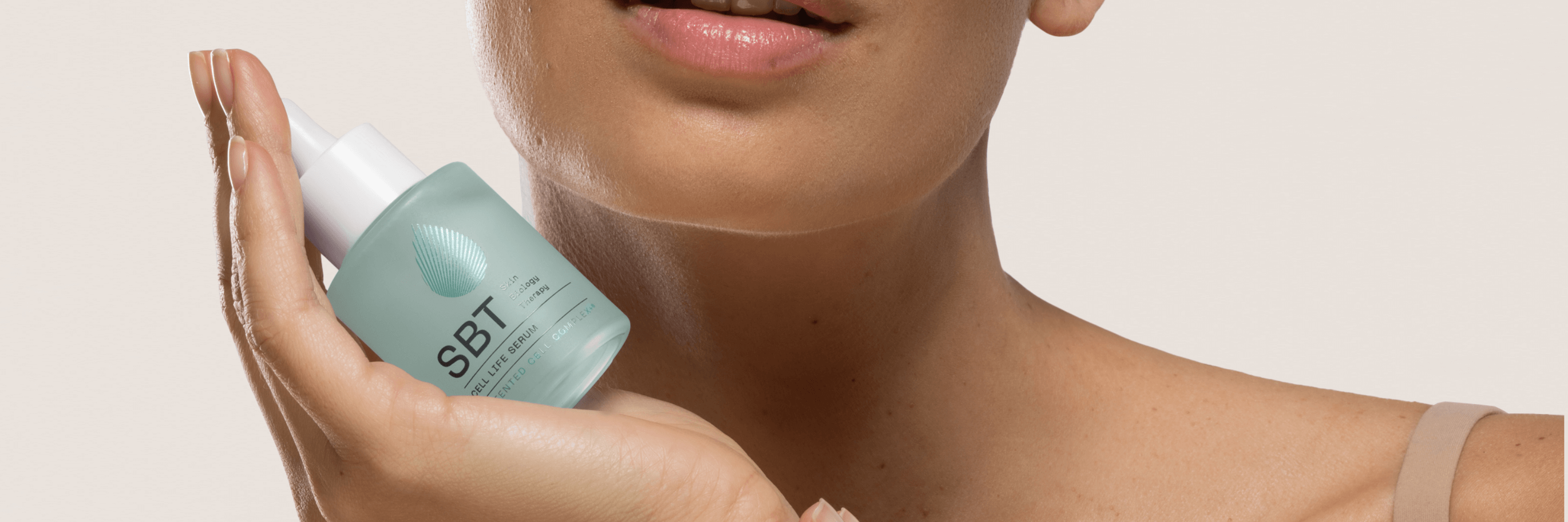 women holding SBT cell life serum in hand with beige background