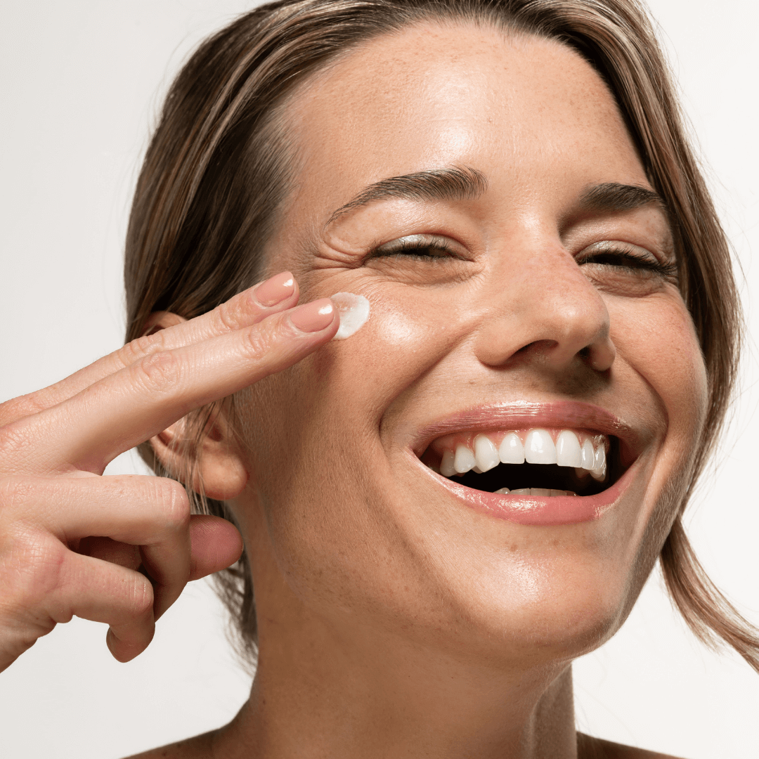 women applying cream on face