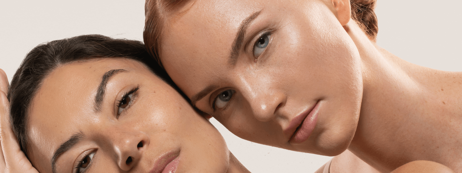two women posing with beige background