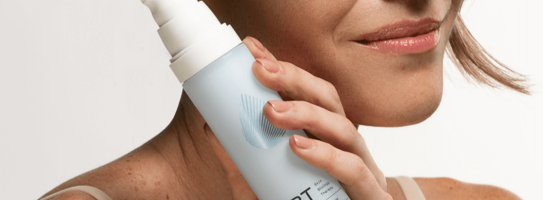 women posing with a blue skincare bottle